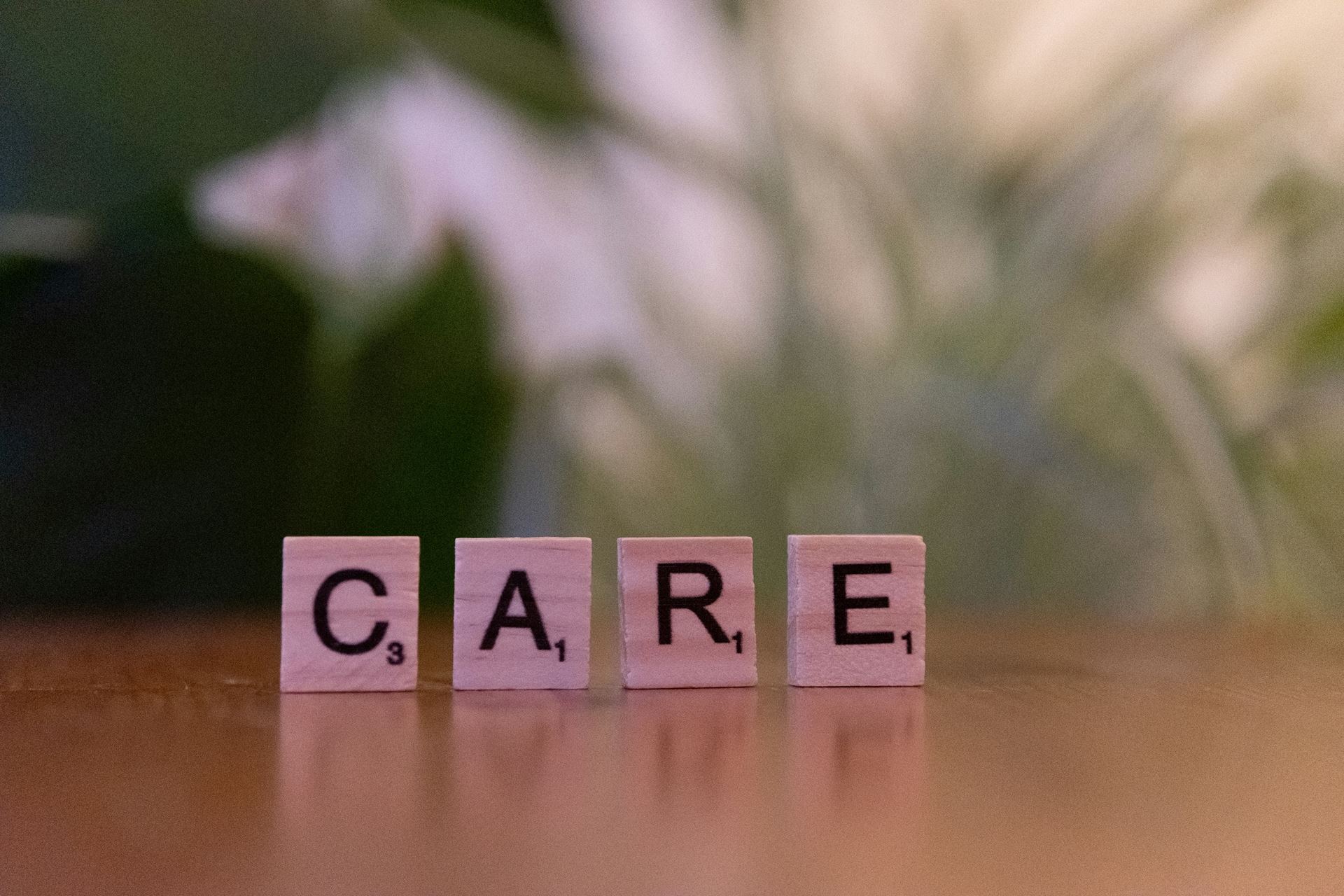 scrabble blocks spelling out the word care
